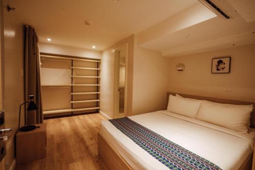 a small bedroom with a bed and a closet at Snooze Inn & Suites in Davao City