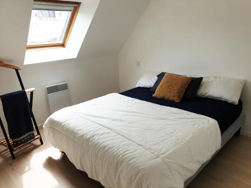 une chambre avec un grand lit blanc avec une fenêtre dans l'établissement DRUIDES 2 - Appartement Carnac-Plage - T85, à Carnac