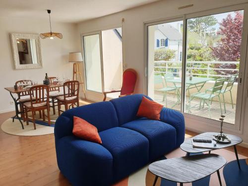 un salon avec un canapé bleu et une table dans l'établissement DRUIDES 2 - Appartement Carnac-Plage - T85, à Carnac