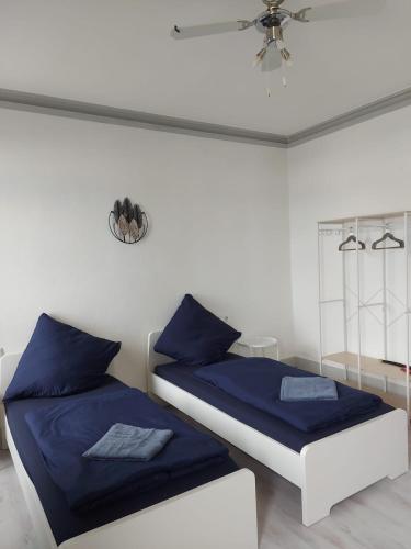 a bedroom with two beds with blue sheets and a ceiling at Monteurwohnung in Reutlingen
