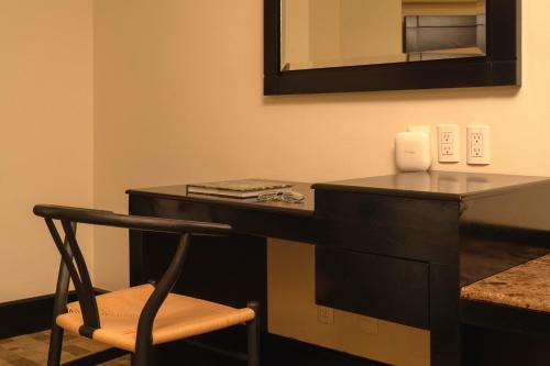 a black desk with a chair and a mirror at Casa del Alma Hotel Boutique & Spa in San Cristóbal de Las Casas