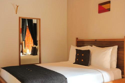 a bedroom with a large bed with a mirror at Sombra del Agua in San Cristóbal de Las Casas