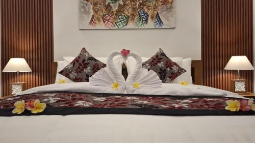 two swans dressed in white are sitting on a bed at Asna House in Ubud