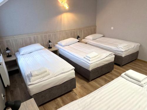 a room with three beds in a room at Karczma u Jakuba in Domaniów