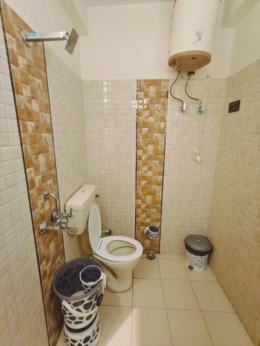 a small bathroom with a toilet and a shower at HOTEL TOURIST REST HOUSE Agra in Agra