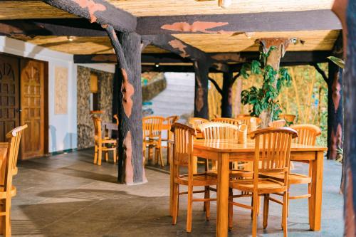 a wooden table and chairs in a room at Butterfly Beach Resort in Taytay