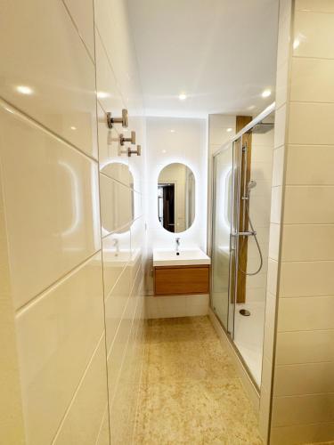 une salle de bain avec une douche, un lavabo et un miroir dans l'établissement BEACH & PALAIS - 2 Min AWAY, BALCONY, à Cannes