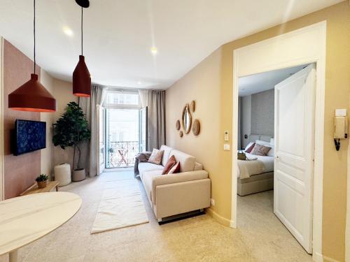 un salon avec un canapé et un lit dans l'établissement BEACH & PALAIS - 2 Min AWAY, BALCONY, à Cannes