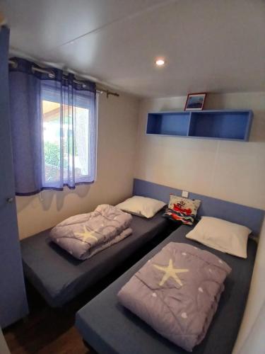 une chambre avec deux lits et une fenêtre dans l'établissement Mobil-Home le Montourey, à Fréjus