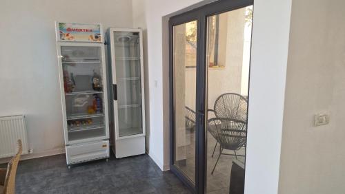 a kitchen with an open refrigerator and a chair at Casa Damian DROBETA in Drobeta-Turnu Severin