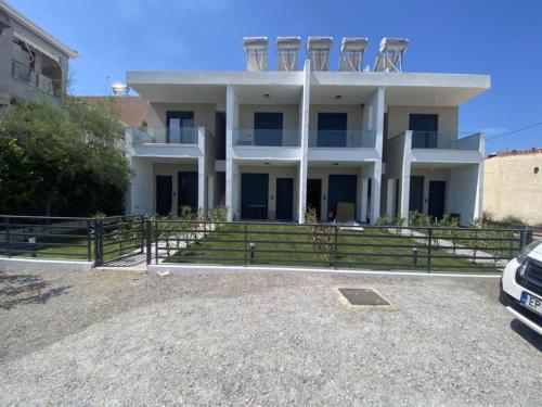een wit huis met stoelen erop bij Sunny Apartment in Ofrínion