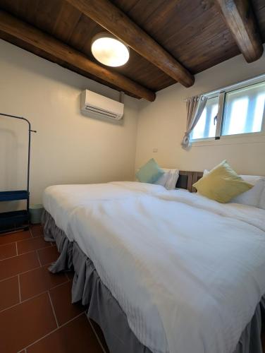a bedroom with two beds and a window at Lanshe Gate in Chung-lan