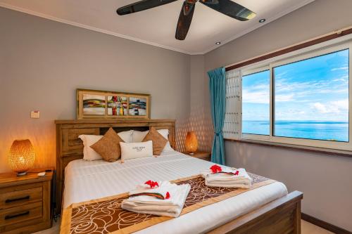 a bedroom with a bed with a large window at Glacis Heights Villa in Glacis