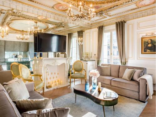 un salon avec un canapé et une table dans l'établissement Merveil - Signature Suite - Louvre - Marcel I, à Paris
