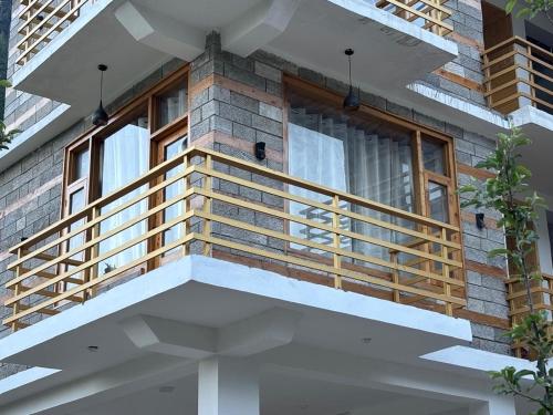 a house with a balcony with a window at deja view orchard, old manali in Manāli