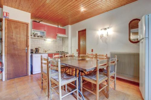 une cuisine et une salle à manger avec une table et des chaises en bois dans l'établissement Spacious 4 Bedroom Apartment in Essert Romand, à Essert-Romand