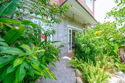 a garden path leading to a house with plants at Ancient Garden Boutique Hoi An in Hoi An
