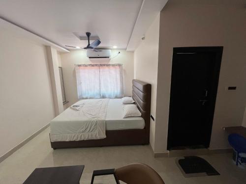 a small bedroom with a bed and a window at Hotel Aero One in Kurnool