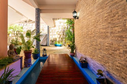 a hallway with a brick wall and potted plants at Glacis Heights Villa in Glacis