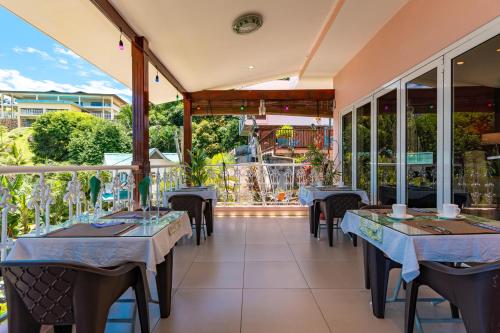 a restaurant with tables and chairs and windows at Glacis Heights Villa in Glacis