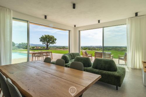 een eetkamer met een tafel en stoelen en grote ramen bij Villa Valentina in Pula