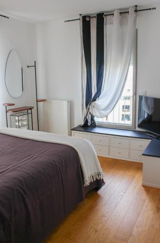 une chambre avec un lit et une grande fenêtre dans l'établissement Spacious Duplex with Terrace City Center, à Aix-en-Provence