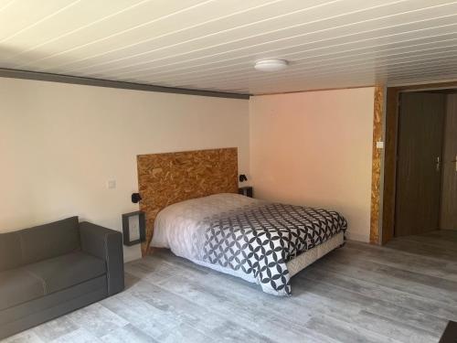 a bedroom with a bed and a couch at Auberge Restaurant La Roseraie in Grandrupt