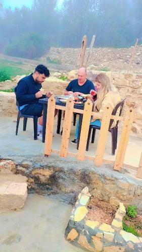 a group of people sitting at a picnic table at Dana Village experience hotel in Dana