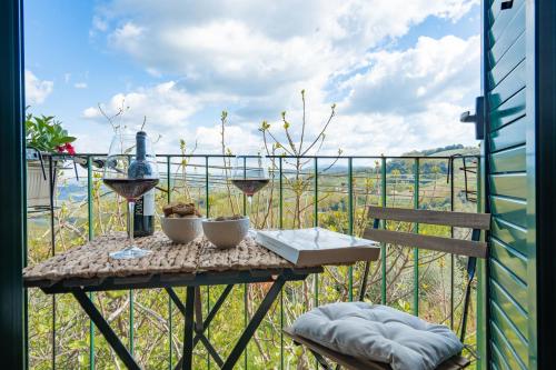 a table with two glasses of wine on a balcony at La Casa dei Fichi in Gambassi Terme