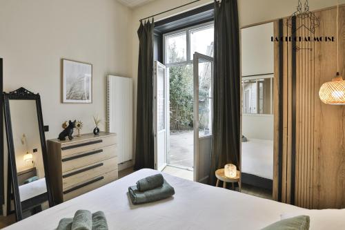 une chambre avec un lit et une grande fenêtre dans l'établissement Capucine - Haussmannien de Charme - 50m plage, à Les Sables-dʼOlonne