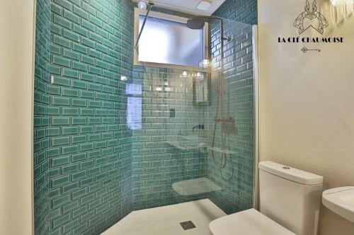 une salle de bain avec toilettes et douche en verre dans l'établissement Capucine - Haussmannien de Charme - 50m plage, à Les Sables-dʼOlonne