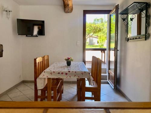 une salle à manger avec une table, des chaises et une télévision dans l'établissement Villa Sainte Roseline -AC, Provençal Garden and BBQ, aux Arcs-sur-Argens