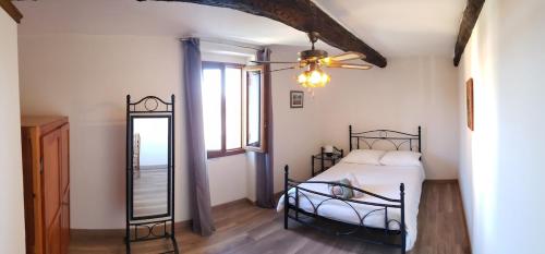 une chambre avec un lit et un ventilateur de plafond dans l'établissement Villa Sainte Roseline -AC, Provençal Garden and BBQ, aux Arcs-sur-Argens