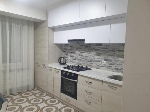 a kitchen with white cabinets and a stove and a sink at Botanica, Shoping Molldova Testimiţianu in Chişinău
