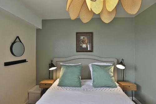 une chambre avec un lit avec deux oreillers dans l'établissement Fregates - Vue mer exceptionelle au 12eme etage, à La Chaume