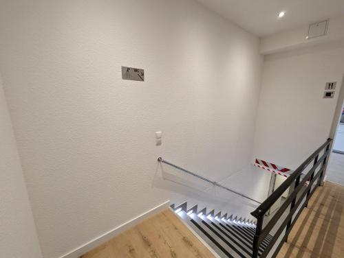 a staircase in a room with white walls at HarmoNest 1 Mgladbach South in Mönchengladbach