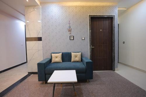 a living room with a blue couch and a door at Royal Taj Twin Palace near Taj Mahal in Agra