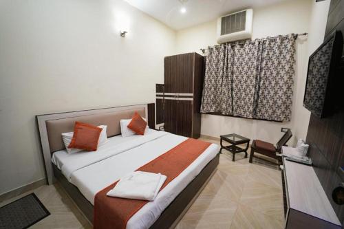 a bedroom with a bed and a chair and a window at Royal Taj Twin Palace near Taj Mahal in Agra