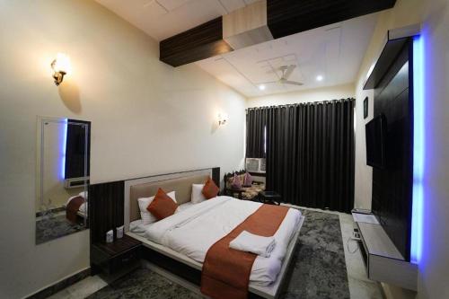 a bedroom with a bed and a television in it at Royal Taj Twin Palace near Taj Mahal in Agra