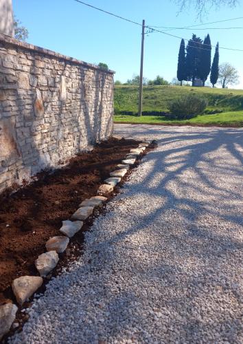 a stone wall next to a dirt road at Apartment 2323 in Foli