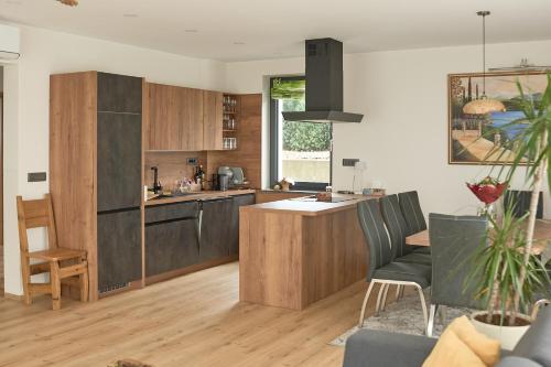 a kitchen with wooden cabinets and a kitchen island at Vila Vinita in Sveti Jurij ob Ščavnici