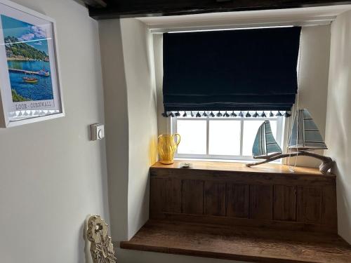 una finestra con una tenda con una barca a vela sopra di Character 3 Bed Cottage, Close to Waters edge, Parking a Looe