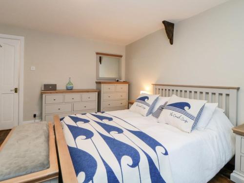 una camera da letto con un grande letto con cuscini blu e bianchi di Character 3 Bed Cottage, Close to Waters edge, Parking a Looe
