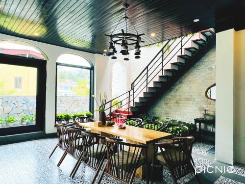 a dining room with a table and chairs and a staircase at Sapa Villa Florence in Sa Pa