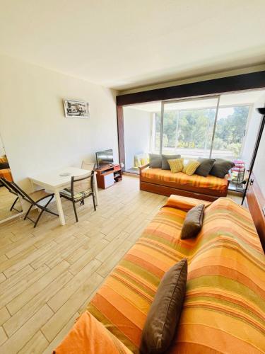 Cette chambre comprend un lit, un canapé et une table. dans l'établissement Studio dans résidence privée paradisiaque, à Bandol