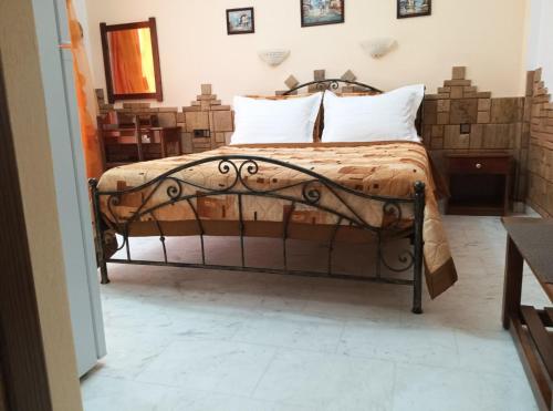 a bed in a room with some pillows on it at Πανσιόν Άγγελος in Ouranoupoli