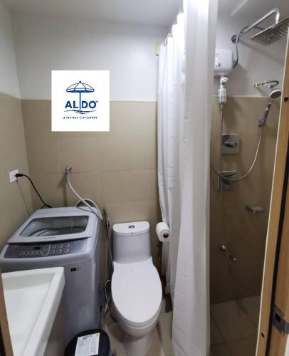 a small bathroom with a toilet and a shower at Mall of Asia condotel shore 3 residence in Manila