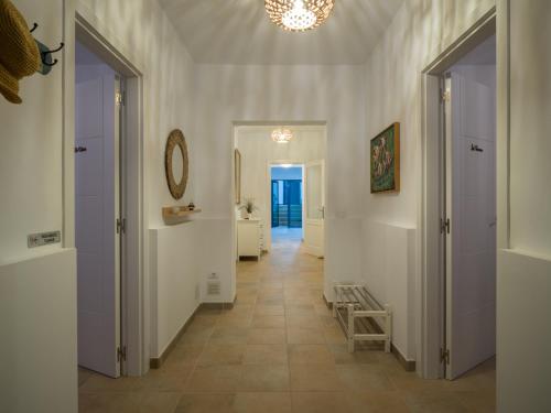 Un pasillo con paredes blancas y suelo de baldosas. en La Casa de La Graciosa, en Caleta de Sebo