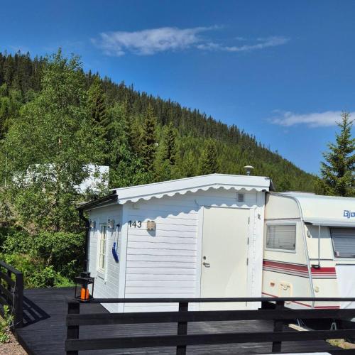 an rv parked in a parking lot next to a forest at Trysil Caravan Cycle in-out in Trysil
