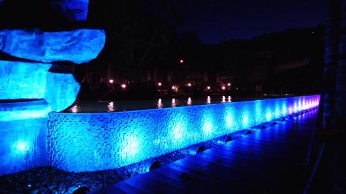a blue led wall with a fountain at night at Unixx South Pattaya by ladda in Pattaya South